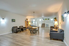 Ein geräumiges Wohnzimmer mit Holzboden, einem Esstisch mit Stühlen und einem Sofa.