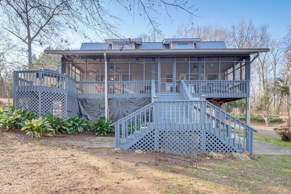 A two-story building with a covered balcony and a staircase leading to the upper level.