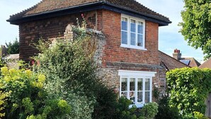 A two-story brick house with a pitched roof, a front porch, and a well-maintained garden. - The Gazebo - Winchelsea Town (East Sussex)