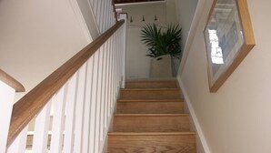 A wooden staircase with white railings and a potted plant at the top. - The Gazebo - Winchelsea Town (East Sussex)