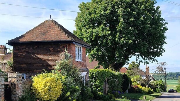 A brick house with a sloped roof, surrounded by well-maintained lawns and a large tree. - The Gazebo - Winchelsea Town (East Sussex)