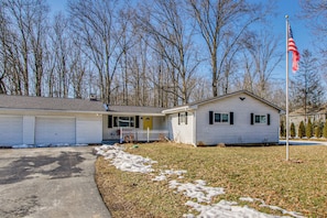 A single-story house with a garage, a front porch, and a flagpole with an American flag. - Peaceful Retreat w/ Private Hot Tub in New Albany (New Albany)