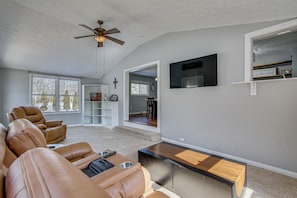 A spacious living room with leather recliners, a ceiling fan, a flat-screen TV, and a wooden coffee table. - Peaceful Retreat w/ Private Hot Tub in New Albany (New Albany)
