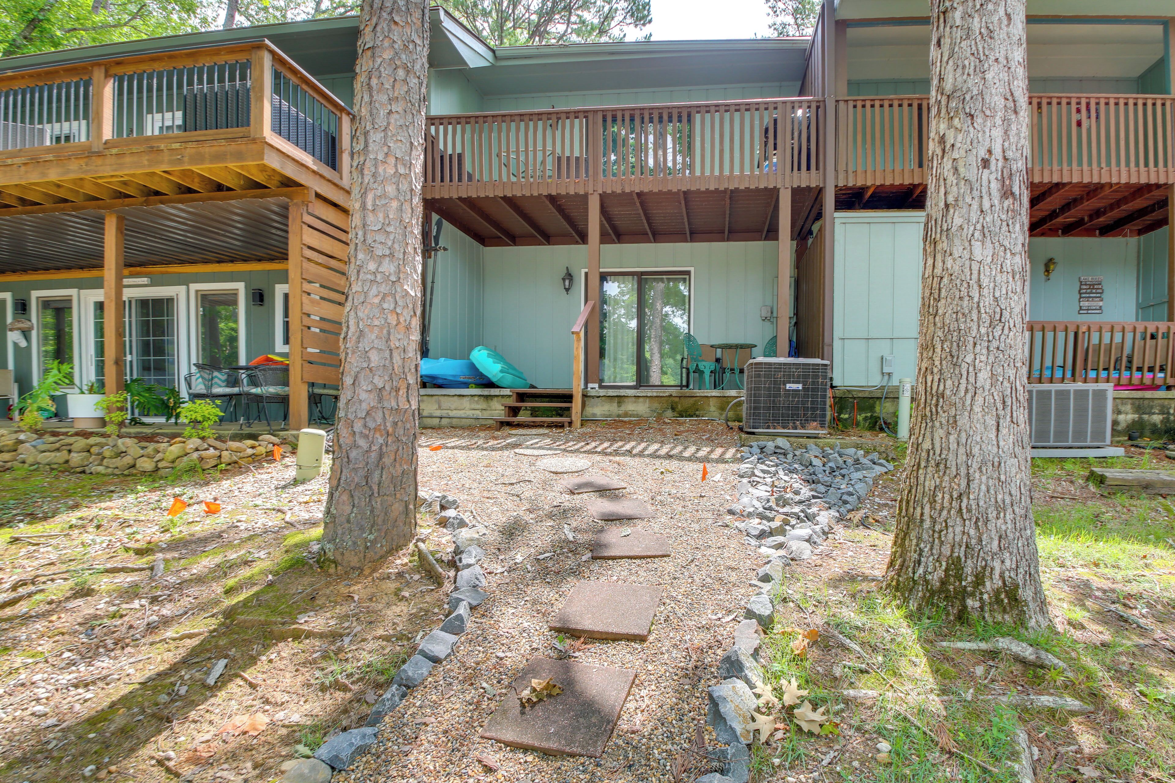 A two-story building with a covered patio area, outdoor seating, and a stone pathway.