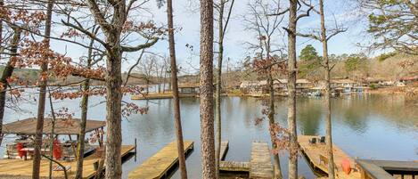 A lakeside view with wooden docks and a covered seating area.