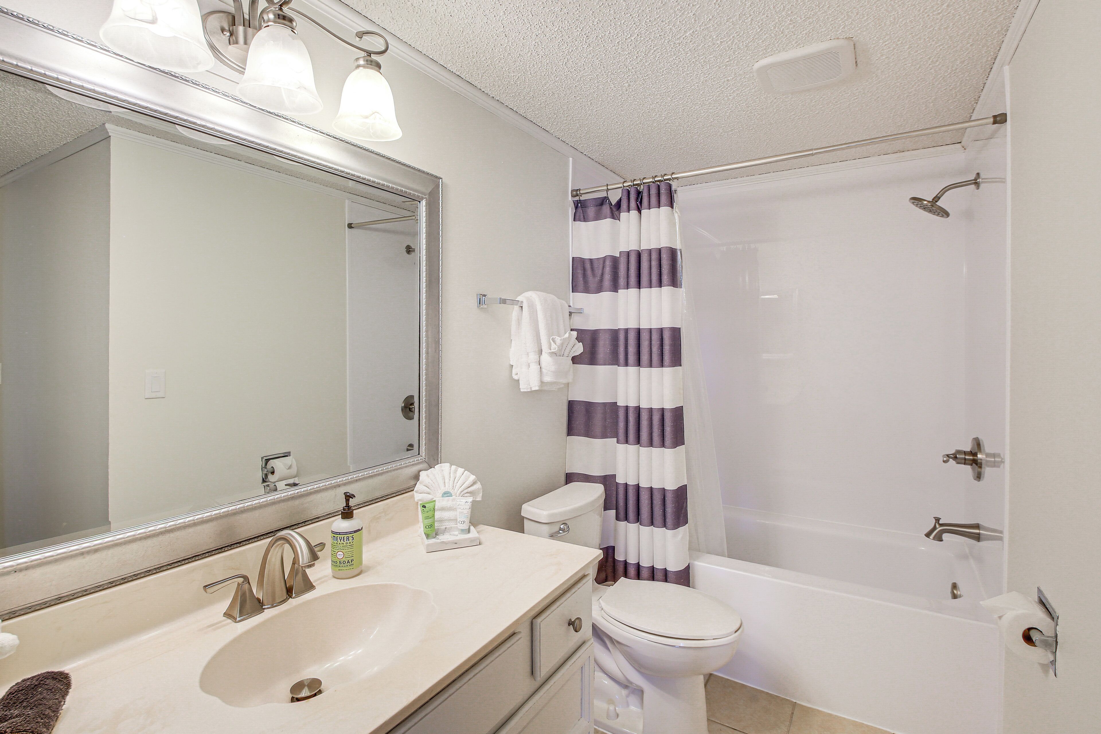 A bathroom with a sink, toilet, and shower.