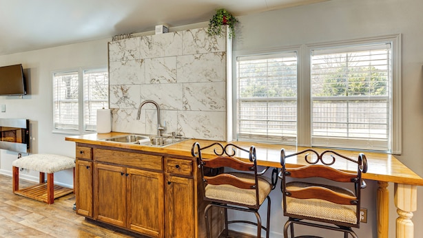 A kitchen with a marble backsplash, wooden cabinets, a wooden island, and two bar stools. - 6 Mi to Clift Farm! Pet-friendly Guesthouse (Harvest)