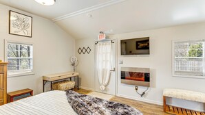 A bedroom with a bed, a bench, a TV, a door with a curtain, and a window. - 6 Mi to Clift Farm! Pet-friendly Guesthouse (Harvest)