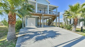 A two-story house with a covered porch and a second-floor balcony. - Blessing By The Bay | Community Pool | Sleeps 8 (Galveston)