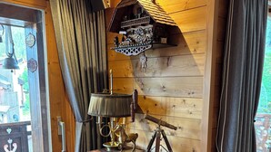 Un intérieur en bois avec un meuble en bois, une horloge et une cloche.