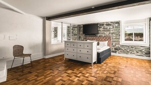 A bedroom with a bed, a dresser, a chair, and a television. - Charming Home with Spectacular Views - NEW! (Bergen)