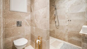 A bathroom with a toilet, a shower, and a sink. - Charming Home with Spectacular Views - NEW! (Bergen)