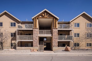 A multi-story building with a central entrance, balconies, and stone pillars. - New Listing! Adventure Ready | Near Arches | Hot Tub + Pool | Views (Moab)