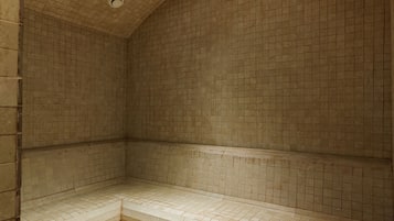 Una habitación con suelo de baldosas, un banco y una rejilla en el techo.