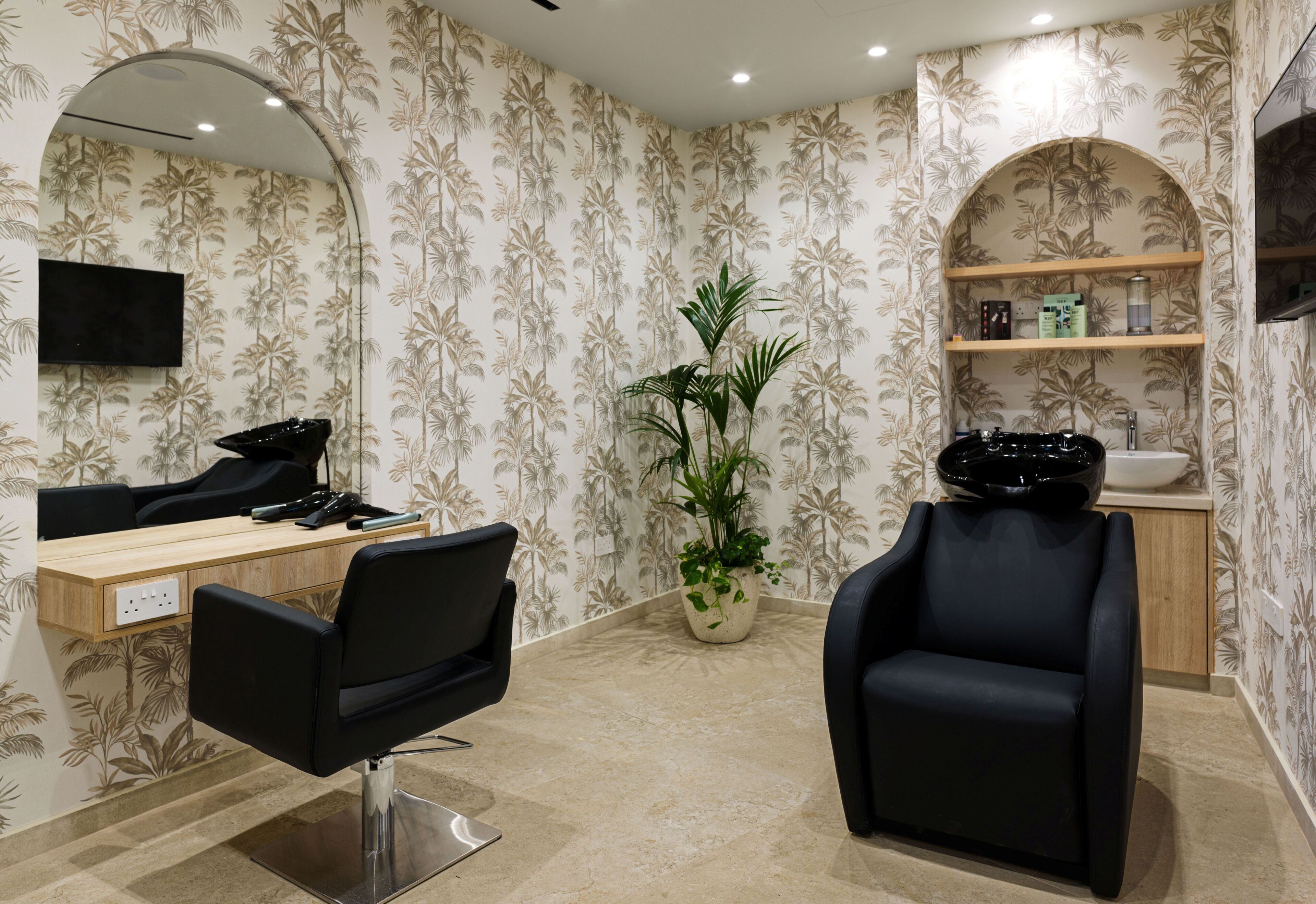 Ein Friseursalon mit modernem Design, mit einem großen Spiegel, einem schwarzen Friseurstuhl, einem Holztisch und einem Topf mit Pflanze.