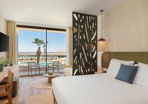 Ein Hotelzimmer mit Bett, Schreibtisch, Stuhl, rundem Tisch, Blick auf Pool und Palmen sowie einem dekorativen Raumteiler.