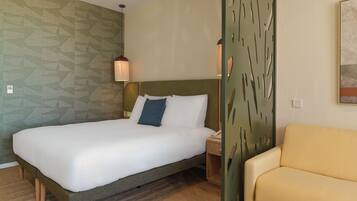 Et hotelværelse med seng, sengebord, lampe, stol og en dekorativ vægpanel.