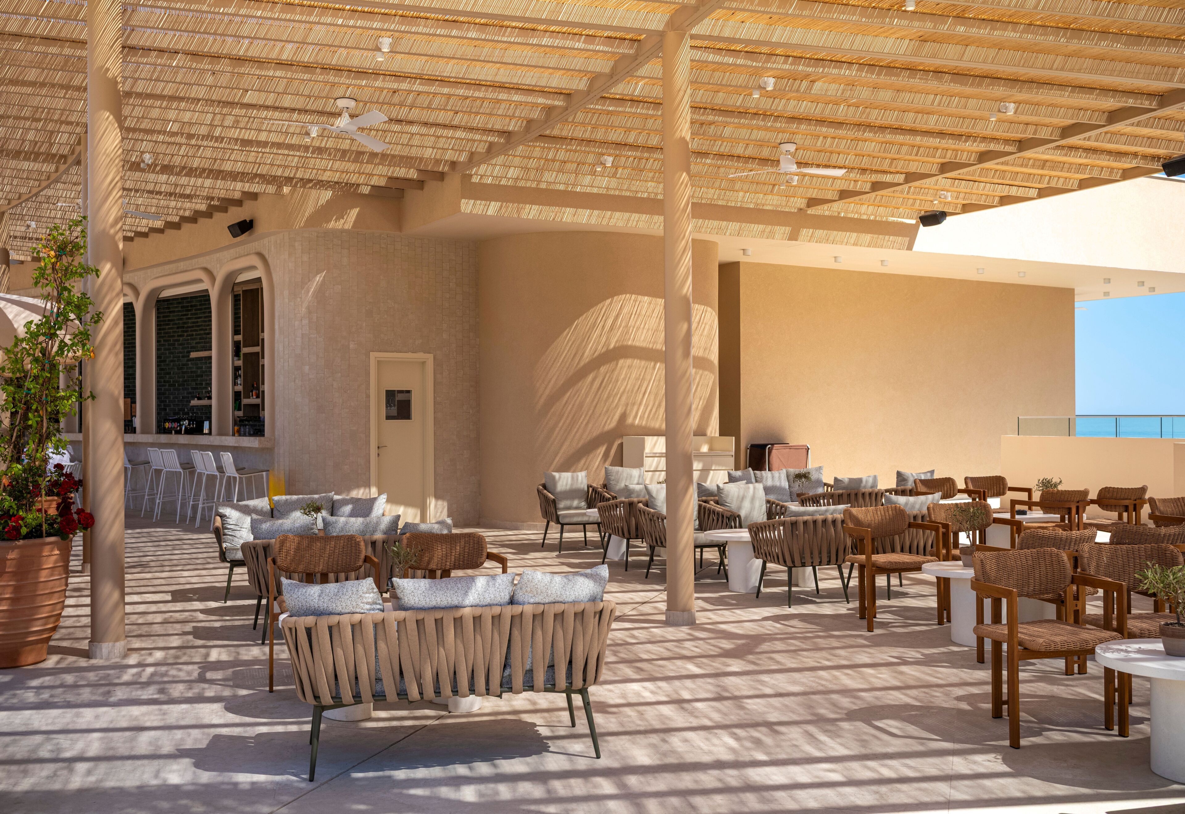 An outdoor seating area with wicker furniture and a thatched roof.