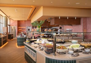 A buffet with various food items and a kitchen area in the background. - NALU Latchi Leonardo Limited Edition (Polis)