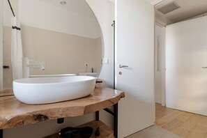 A bathroom with a large white vessel sink, a wooden countertop, a mirror, and a white door. - GuestHost - A comfortable and bright 55 square meters apartment, perfect for four people, located on the first floor of a building with an elevator (NOT accessible to disabled guests).The property is located in the Cascina Merlata neighborhood, a growing (Milan)