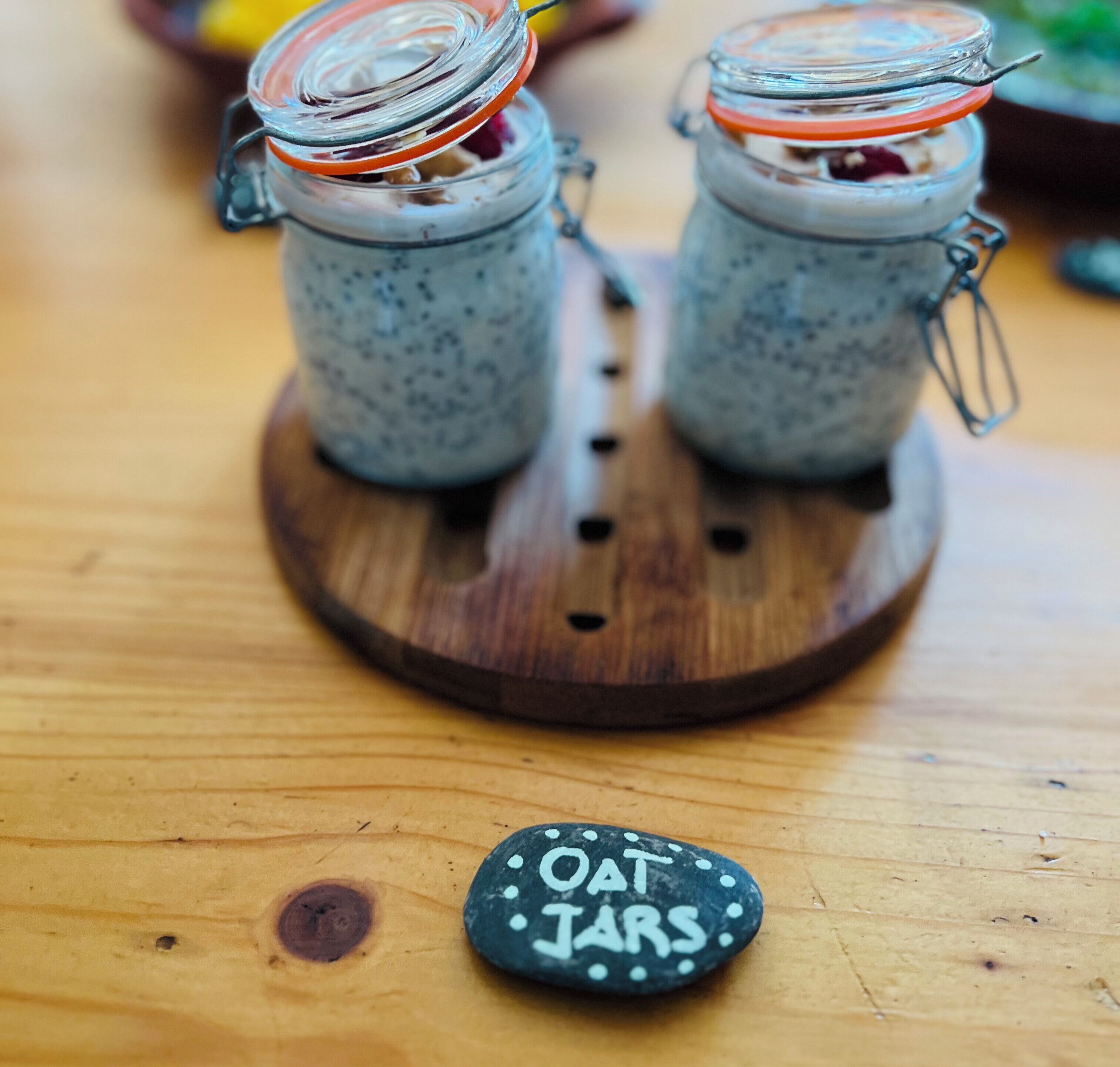 Two glass jars with metal lids on a wooden board.