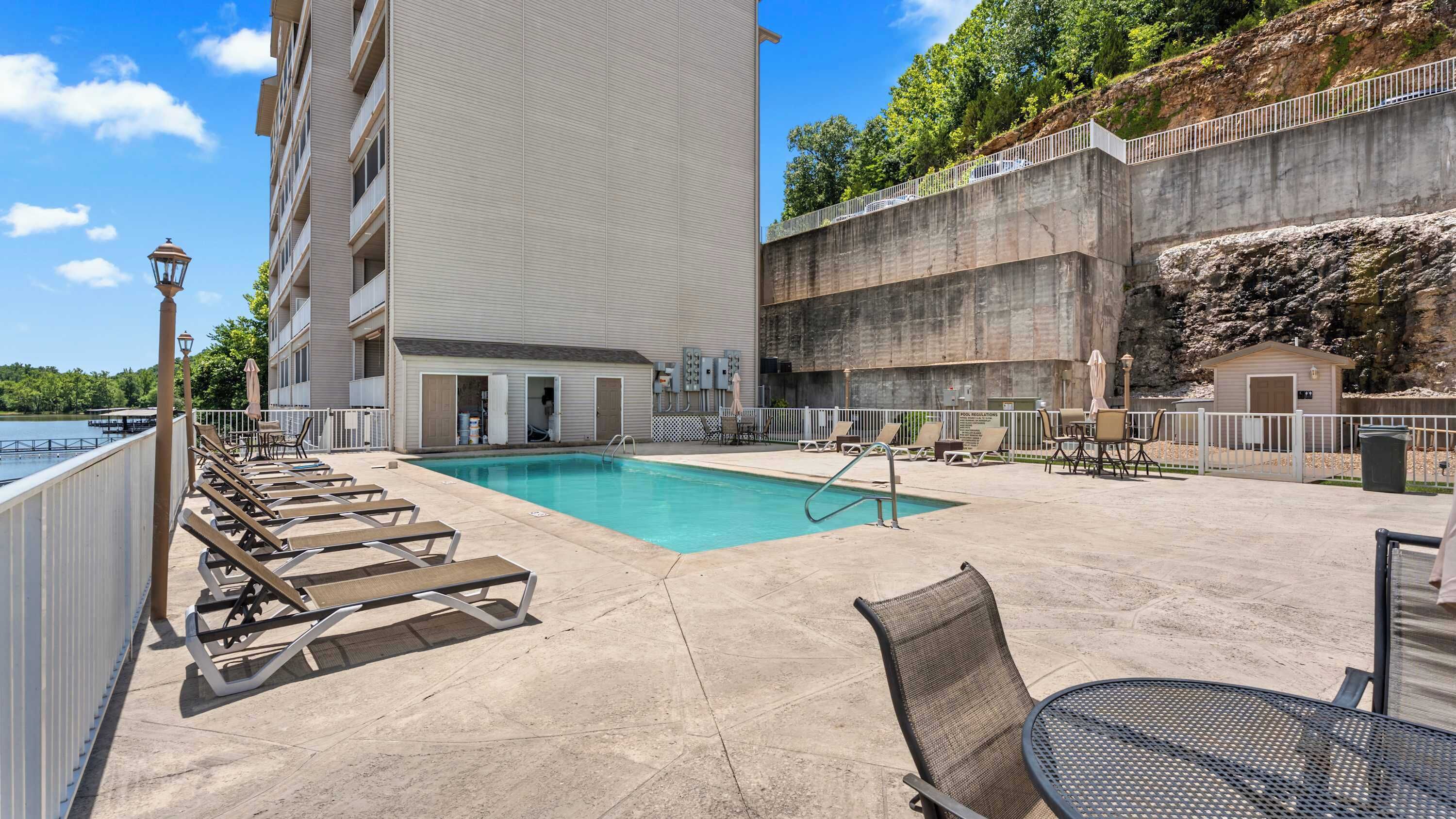 A pool area with lounge chairs and a small pool.