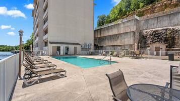 A pool area with lounge chairs and a small pool.