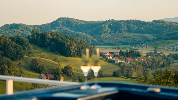 A view of a rural landscape with rolling hills and scattered houses.