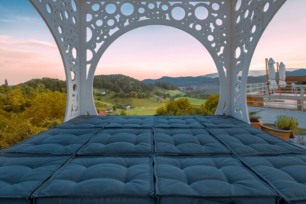 Ein Zimmer mit Blick auf eine Landschaft durch eine weiße, verzierte Struktur.