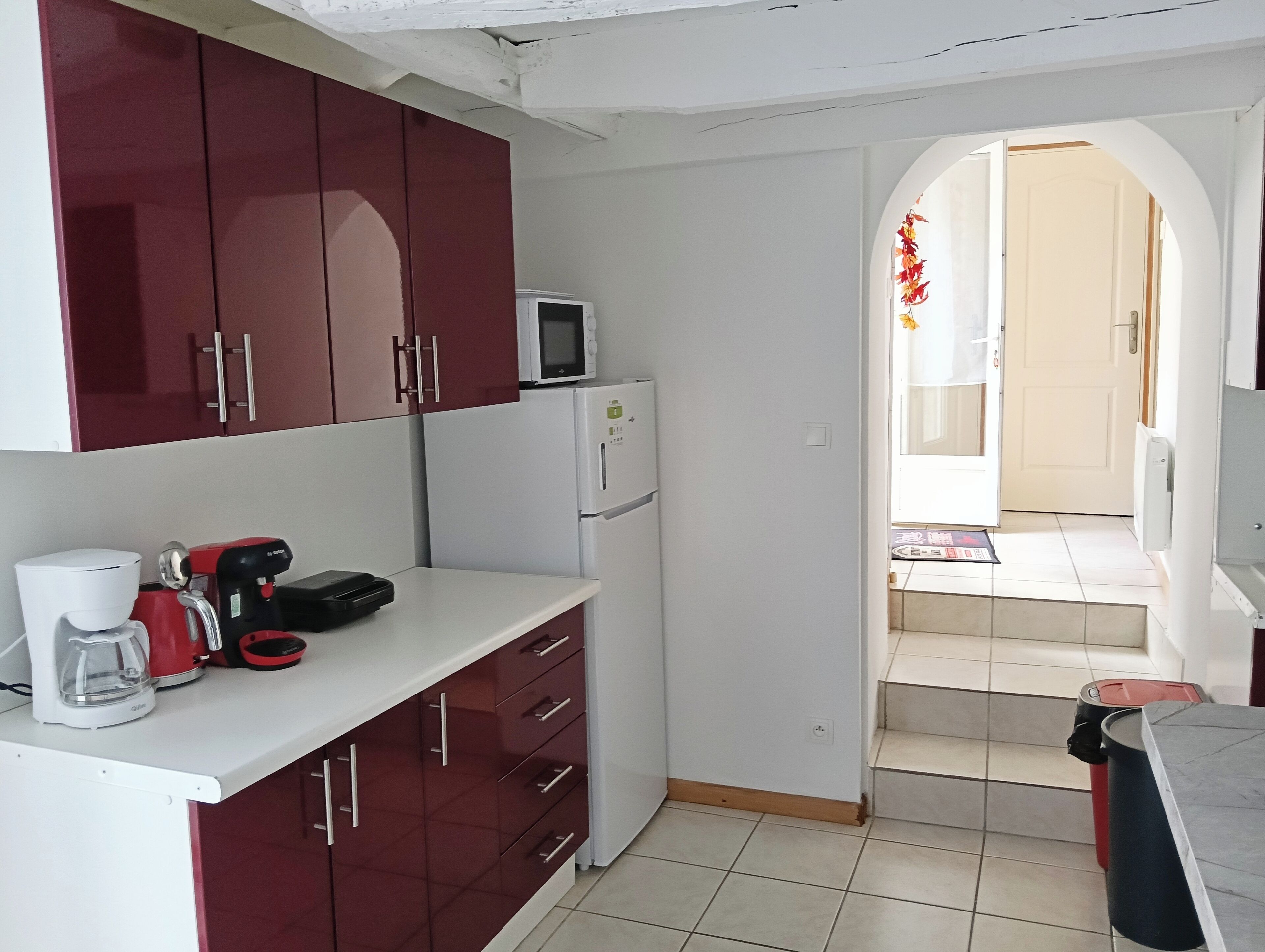 A compact kitchen with a microwave, refrigerator, and coffee maker.