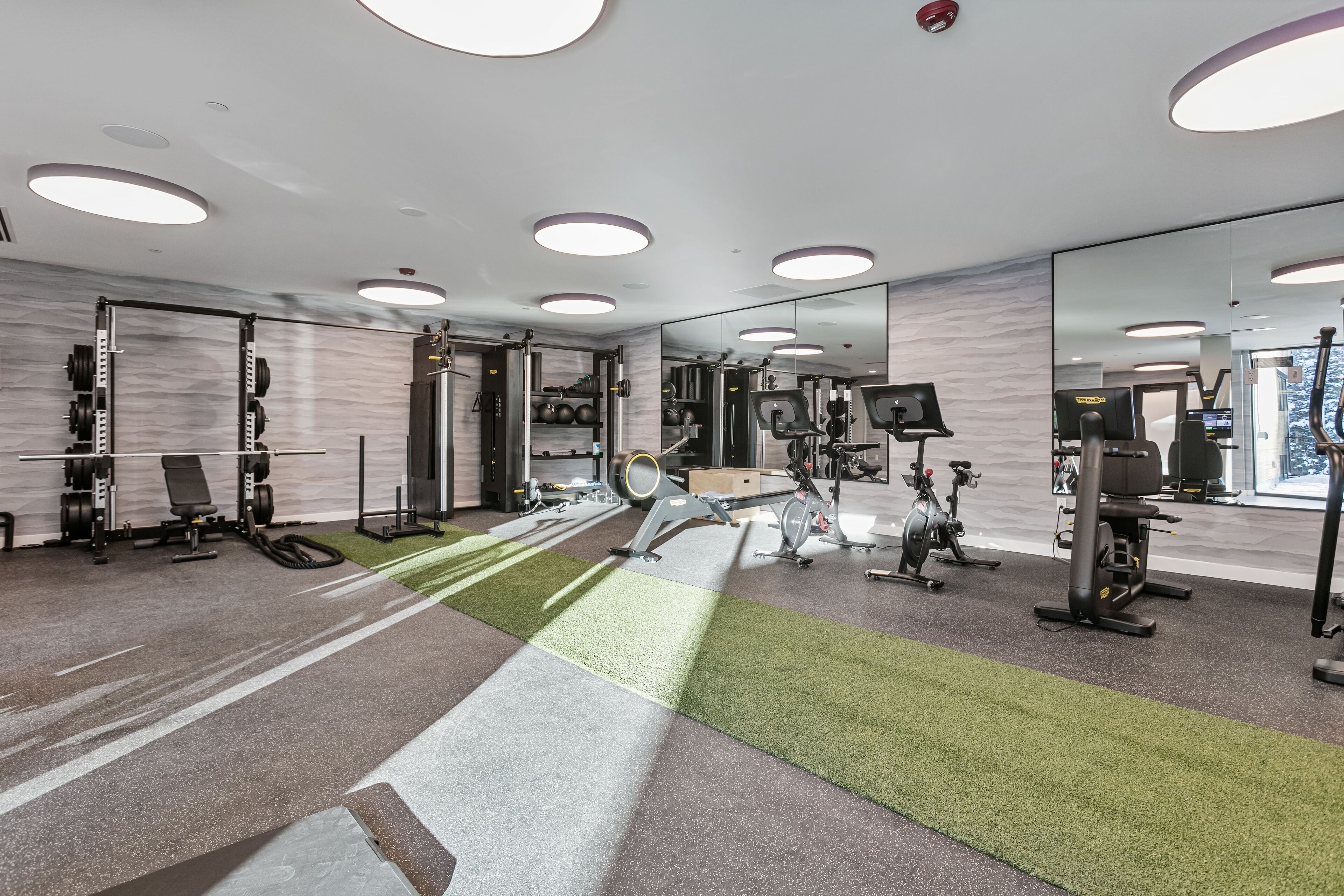 A modern gym with various exercise equipment, including weight machines, treadmills, and stationary bikes.