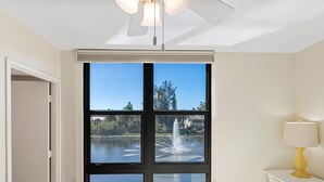 A bedroom with a large sliding glass door leading to a water feature and a view of trees. - PRIVATE BEACH ACCESS, SPRING-FED LAKE, WALK TO SIESTA KEY VILLAGE! (Siesta Key)
