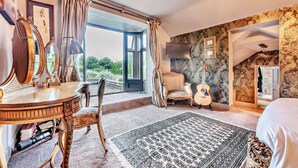 A bedroom with a large window, a wooden vanity, a guitar, and a patterned rug. - Stunning English country house in rural Kent (Eastry)