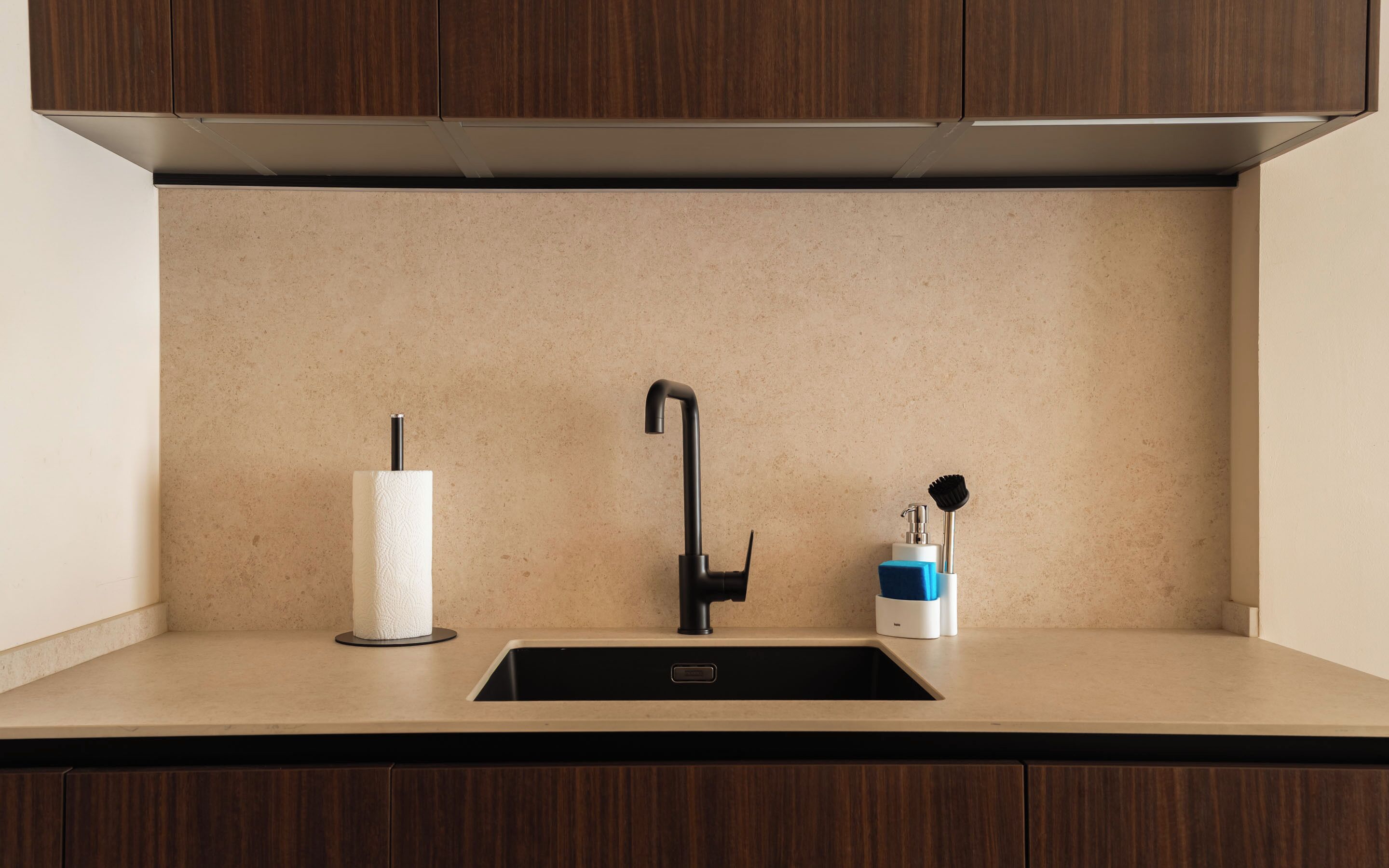 Una cocina con un grifo moderno, un dispensador de toallas de papel y un dispensador de jabón.