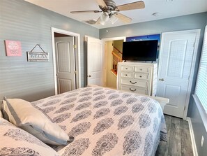 A bedroom with a bed, dresser, TV, and ceiling fan. - 4 Bedroom Townhouse, sleeping 12, Walk to the Beach, FREE Linens & Towels (Ocean City)