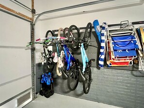 A garage with bicycles, helmets, and a stroller. - 4 Bedroom Townhouse, sleeping 10, Walk to the Beach, FREE Linens & Towels (Ocean City)