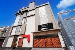 A modern building with a company-serviced sign, a red number 7, and a gated entrance. - Collection O Aiims Bhubaneshwar (Bhubaneshwar)