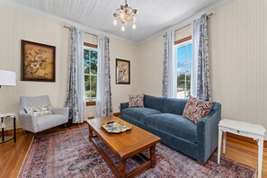 Un salon comprenant un canapé, un fauteuil, une table basse et un tapis.