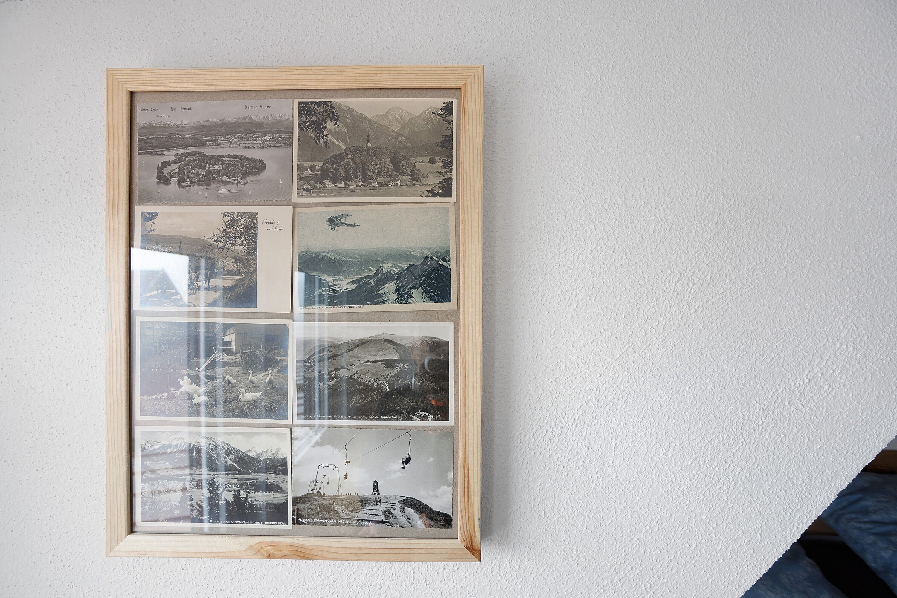 Un collage de photographies encadrées accroché au mur.