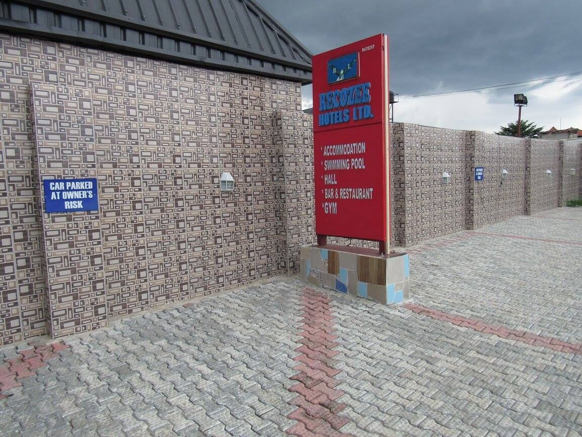 Une enseigne d’hôtel indiquant les équipements disponibles : hébergement, piscine, salle, bar-restaurant et salle de sport.