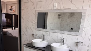 A bathroom with two sinks, a large mirror, and a toilet. - Castle Rock Guest House  (Bulawayo)