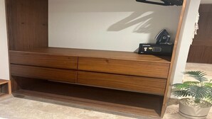 Un banco de madera con respaldo blanco y un pequeño dispositivo negro encima.