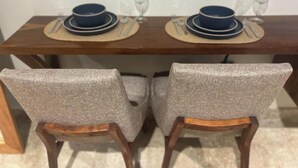 Una mesa de comedor con dos sillas, cada una con un cojín de asiento tejido.