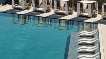 A poolside area with multiple sunbeds and a clear pool.