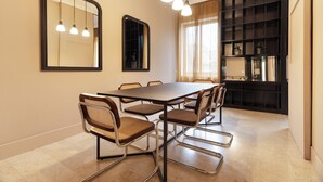 Un comedor con una mesa rectangular, seis sillas y tres lámparas colgantes.