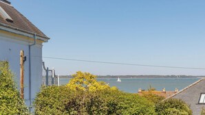 Blick auf die Küste mit einer Brücke, einem Segelboot und Gebäuden.