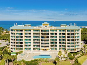 A multi-story hotel with a pool, surrounded by greenery and overlooking the ocean. - The Indies #209 | Quiet Beach, Pool, Hot Tub, Gym, Rooftop Deck (Gulf Shores)