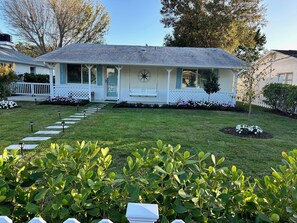 A house with a front porch, a star decoration, and a well-maintained lawn. - Charming Beach Cottage with Hot Tub only 1 Mile to Gulf! (Naples)