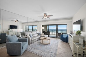 A modern living room with a sofa, armchairs, a coffee table, and a view of the ocean. - Gulf Front - Boat Slips Available - Shipwatch D403 - Signature Properties (Perdido Key)