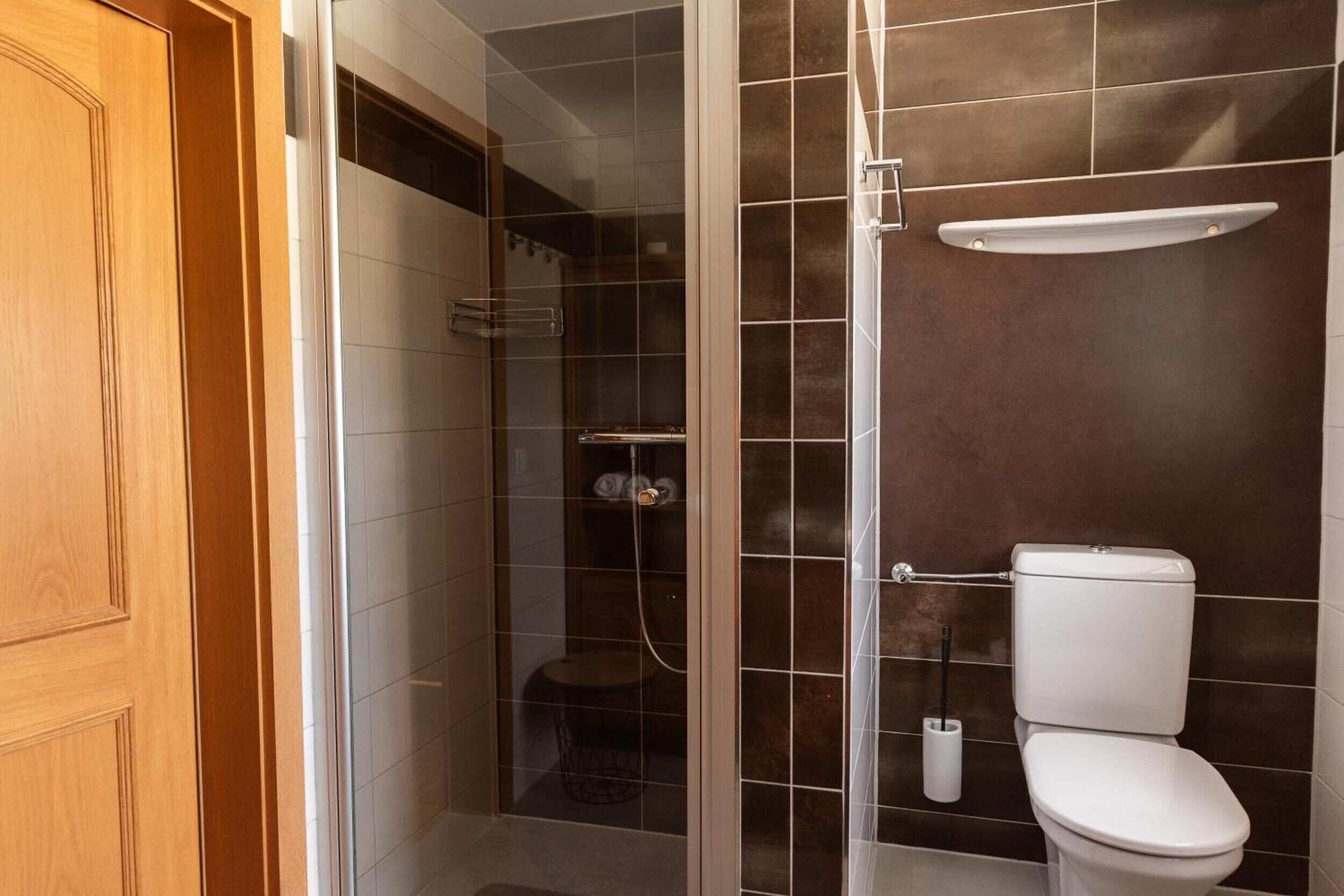 Une salle de bain avec une douche, des toilettes et un porte-serviettes.